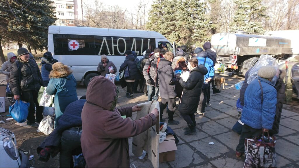 Люди розбирають гуманітарку, яку привіз Євген